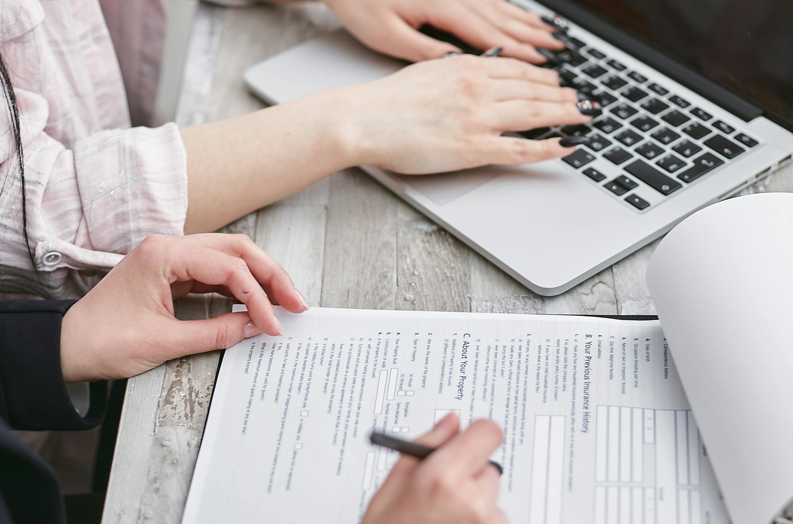 Hands on a laptop and examining customer documents